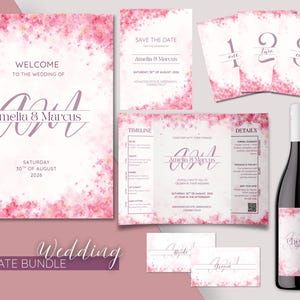 Puede incluir: Un paquete de plantillas para bodas con invitaciones, tarjetas de guardar la fecha, números de mesa y tarjetas de lugar. El diseño incluye acentos florales rosas y los nombres Amelia & Marcus. También se incluye una botella de vino con una etiqueta "Cheers".