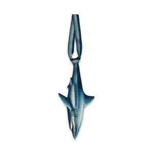 May include: A shark-shaped ornament in shades of blue and grey, featuring a smooth, streamlined body with visible gills and fins. The shark is suspended from a matching blue fabric loop at the top, designed for hanging as a decorative accent piece.