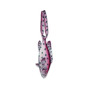 May include: A necktie shaped like a fish with a pink and white gradient body covered in dark blue polka dots. The tie features a fish head at the bottom, fins on the sides, and a long, narrow neck strap that continues the same spotted pattern.