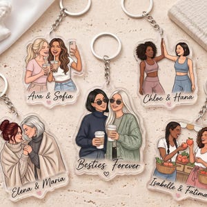 以下が含まれることがあります： Ava & Sofia、Chloe & Hana、Elena & Maria、Besties Forever、Isabelle & Fatimaという名前が印刷された、ペアのイラスト入り透明アクリルキーホルダー5点。各キーホルダーにはシルバーの金属製リングとチェーンが付いています。