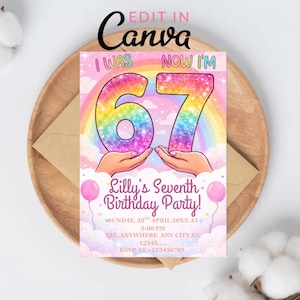 May include: A birthday party invitation card with the text "I WAS" and "NOW I'M" above a large, rainbow-coloured "67". The card includes the text "Lilly's Seventh Birthday Party!" and event details. The card is on a wooden tray.