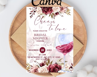 May include: Bridal shower invitation with floral design and a wine glass illustration. The invitation includes the text "Cheers to love" and event details. The design features burgundy and cream-colored roses. The invitation is on a wooden plate.
