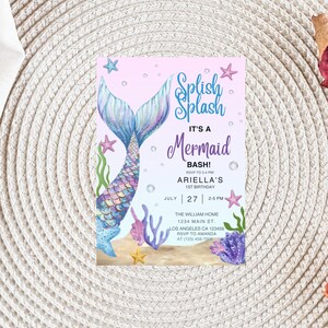 May include: A mermaid-themed invitation with a watercolor design. The invitation features a mermaid tail, starfish, and aquatic plants. Text includes "Splish Splash," "It's a Mermaid Bash!" and event details for Ariella's 1st birthday.