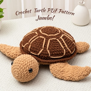 Puede incluir: Una gran tortuga de ganchillo hecha a mano en tonos marrones y beige. La tortuga tiene un caparazón texturizado con detalles beige claro, una cabeza redonda y cuatro extremidades en forma de aleta. El texto "Crochet Turtle PDF Pattern Jumbo!" está visible.