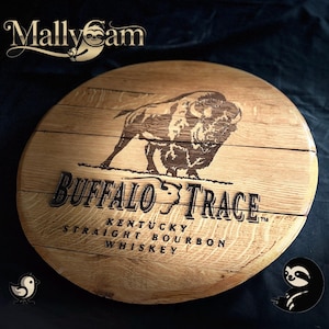 May include: A circular wooden sign displaying the Buffalo Trace logo, with a bison illustration and text. The sign is made of light brown wood and has the words "Kentucky Straight Bourbon Whiskey" engraved on it.