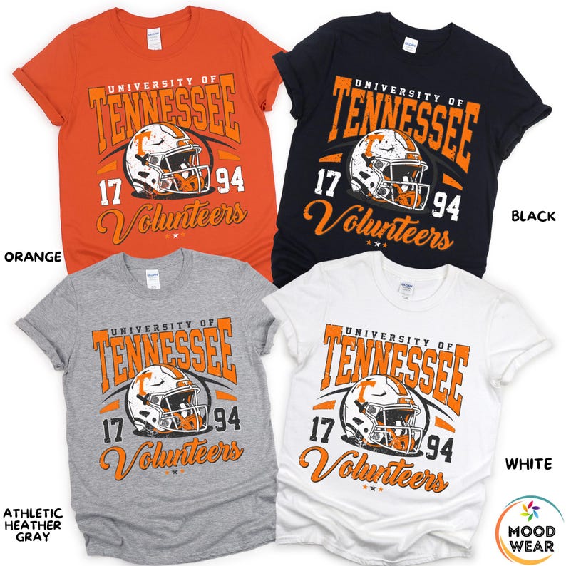May include: Four short-sleeved t-shirts in orange, black, athletic heather gray, and white. Each shirt features the text "University of Tennessee" and "Volunteers" with a football helmet graphic. The numbers "17" and "94" are also displayed.