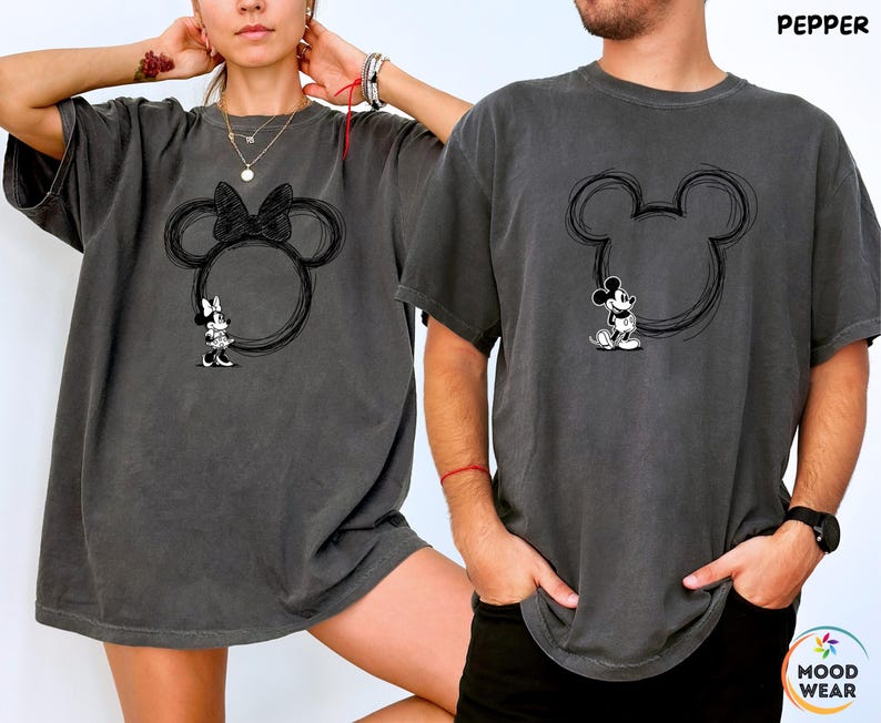 May include: Two dark gray t-shirts featuring a Mickey Mouse design. One shirt has a Minnie Mouse design with a bow, and the other has a Mickey Mouse design. The word "PEPPER" is printed on the top right of the image.