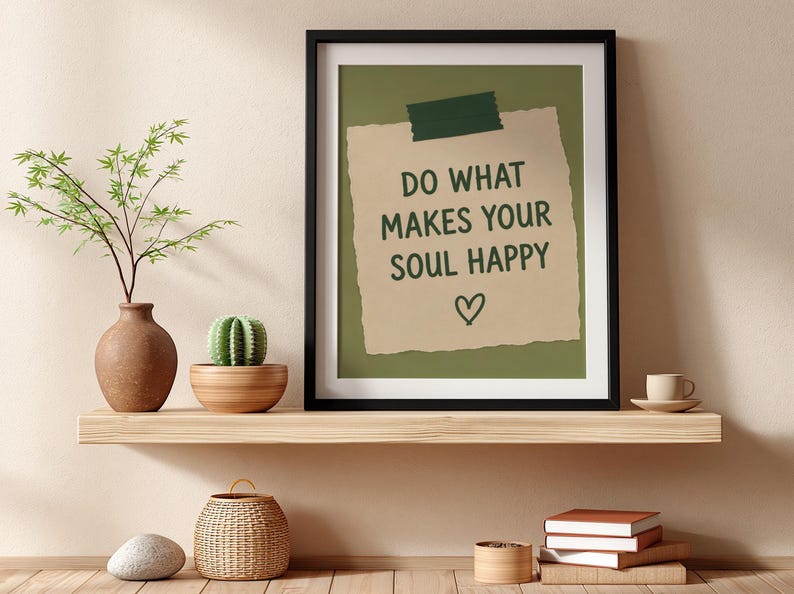 Pu&ograve; includere: Una stampa artistica con cornice nera che presenta una nota di carta color marrone chiaro fissata con nastro adesivo verde scuro su uno sfondo verde oliva. Il testo recita DO WHAT MAKES YOUR SOUL HAPPY sopra un piccolo cuore disegnato a mano.