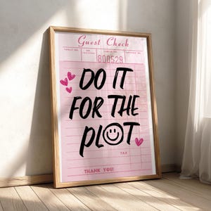 May include: A framed wall art print featuring a pink guest check design with the text "DO IT FOR THE PLOT" in bold black lettering. The design includes small pink heart illustrations, a smiley face icon, and the text "Guest Check" and "THANK YOU!"