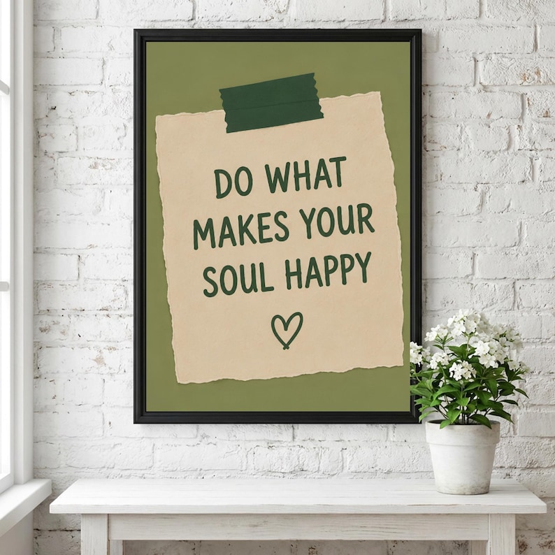 Pu&ograve; includere: Una stampa incorniciata che mostra un foglietto di carta beige dai bordi strappati fissato con un pezzo di nastro adesivo verde scuro su uno sfondo verde oliva. Il testo DO WHAT MAKES YOUR SOUL HAPPY &egrave; scritto in verde scuro sopra un cuore.