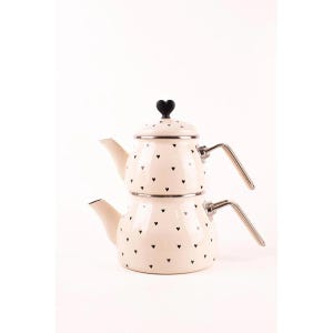 May include: Cream-coloured, two-tiered teapot set with black heart-shaped accents. The set includes a lid with a black heart-shaped handle and two silver-toned handles. The teapot is designed for serving tea and has a classic, elegant look.