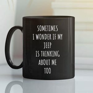 May include: Black ceramic mug with a curved handle. The mug features white text that reads, "SOMETIMES I WONDER IF MY JEEP IS THINKING ABOUT ME TOO."