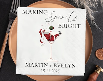 May include: White cocktail napkin with the text "MAKING Spirits BRIGHT" and a cartoon of Santa Claus in a martini glass. The napkin also includes the names "MARTIN + EVELYN" and the date "15.11.2025".