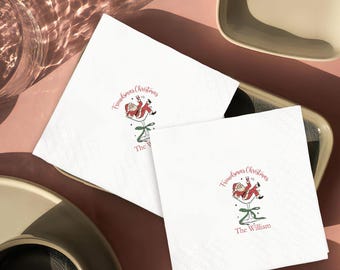 May include: White Friendsmas Christmas cocktail napkins with a Santa Claus illustration in a martini glass. The napkins have a diamond pattern and the text "Friendsmas Christmas" and "The William" in burgundy.