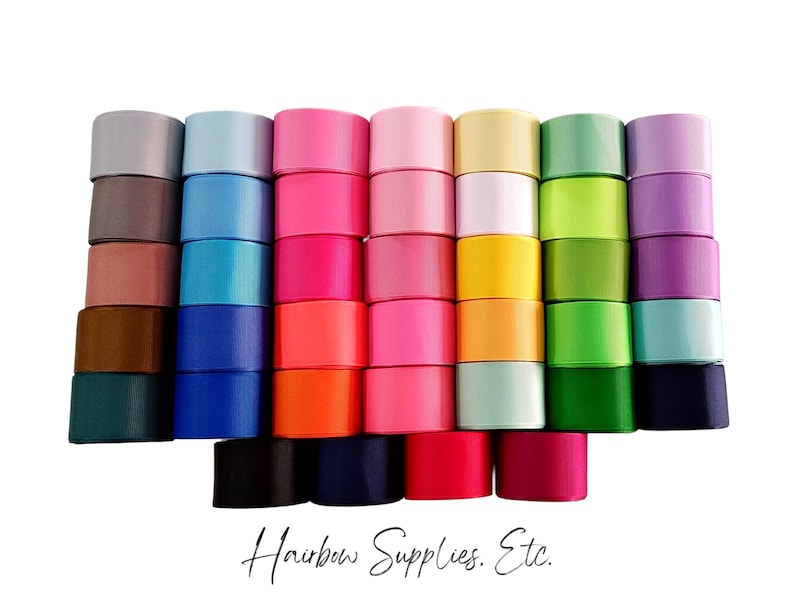 Puede incluir: Surtido de 20 rollos de cinta de sat&eacute;n en varios colores, incluyendo rosa, azul, verde, morado y amarillo. La cinta est&aacute; dispuesta en filas, con cada rollo apilado uno encima del otro. La cinta es perfecta para manualidades, decoraci&oacute;n y envolver regalos.
