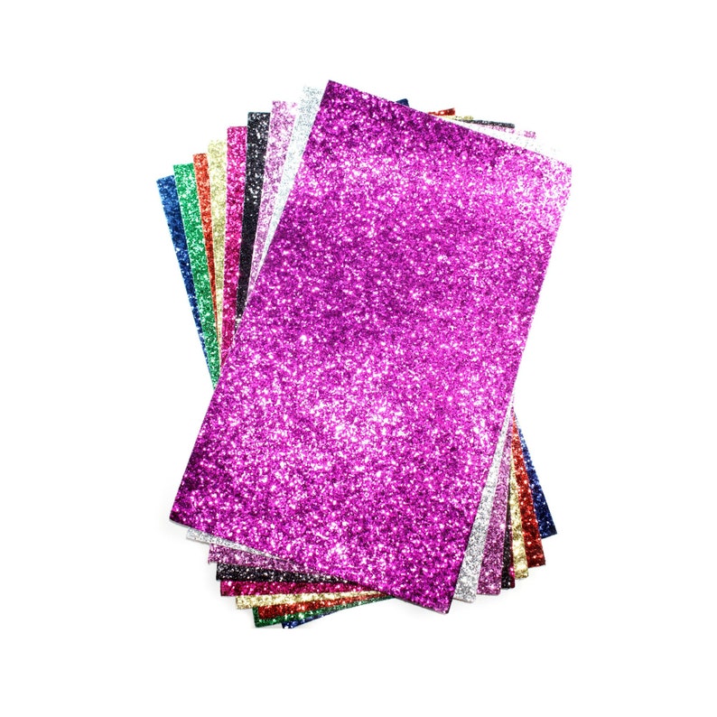 Puede incluir: Una pila de hojas de papel de purpurina de colores en varios tonos de rosa, morado, azul, verde, rojo, dorado y plateado. La hoja superior es de un color magenta vibrante.