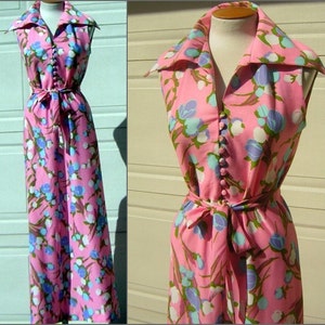 K&ouml;nnte beinhalten: Ein pinkfarbenes, &auml;rmelloses Maxikleid mit einem wei&szlig;en und blauen Blumendruck. Das Kleid hat einen Kragen, eine Knopfleiste vorne und einen Bindeg&uuml;rtel in der Taille.