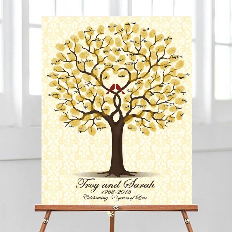 Peut inclure: Un arbre dor&eacute; avec un tronc et des branches marrons, sur lequel sont perch&eacute;s deux oiseaux rouges. L'arbre est entour&eacute; d'un fond blanc avec un motif damass&eacute;. Le texte "Troy and Sarah 1963-2013 Celebrating 50 Years of Love" est en bas de l'image.