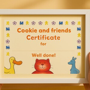 May include: A framed certificate with the text "Cookie and friends Certificate for Well done!" The certificate features illustrations of a yellow duck, a red cat, and a blue kangaroo. The frame is white.