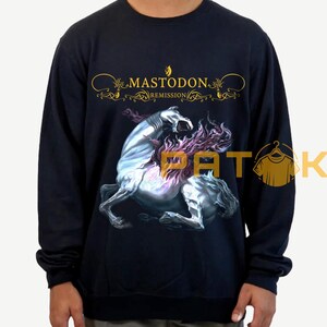 May include: Black sweatshirt featuring the band name "Mastodon" in gold script above a graphic of a rearing, spectral horse with purple flames. The sweatshirt is a dark navy blue.