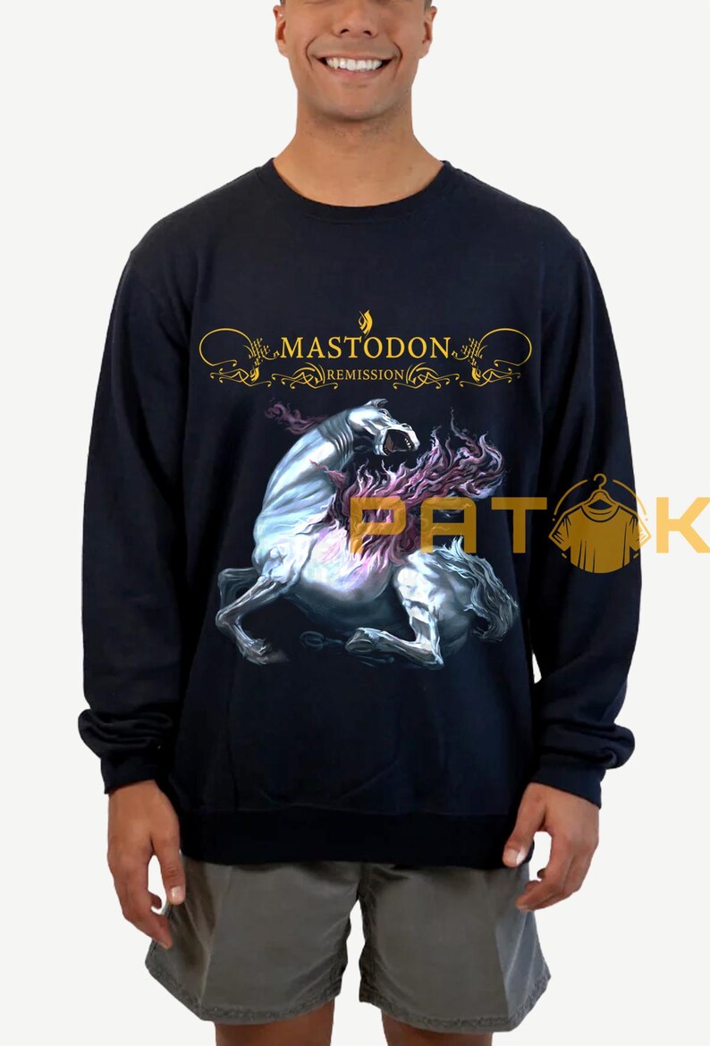 May include: Black sweatshirt featuring the band name "Mastodon" in gold script above a graphic of a rearing, spectral horse with purple flames. The sweatshirt is a dark navy blue.