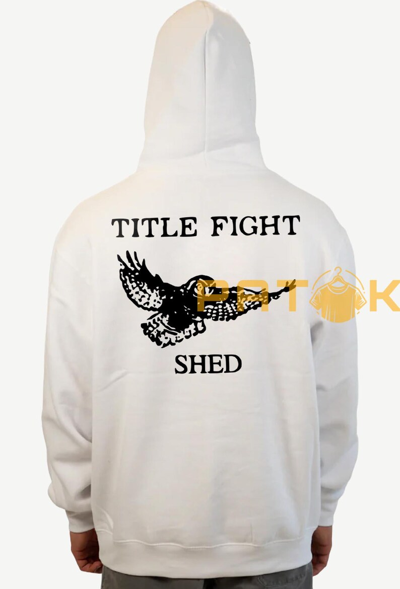 May include: White hooded sweatshirt featuring a black owl graphic and the text "TITLE FIGHT SHED". The design is printed on the back of the garment. The hoodie has a hood and long sleeves.