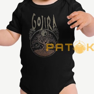 May include: Black baby bodysuit with a gold-colored graphic. The graphic features the word "GOJIRA" above a tree of life design with a moon and a snake. The bodysuit has short sleeves.
