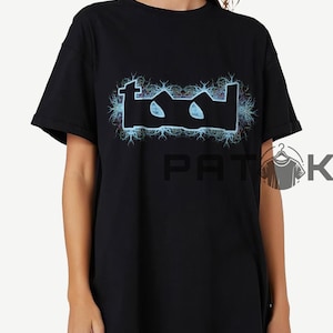 May include: Black t-shirt with the band name "TOOL" in a stylized, electric blue design. The logo is surrounded by a blue and white lightning bolt pattern. The shirt has a classic crew neck.