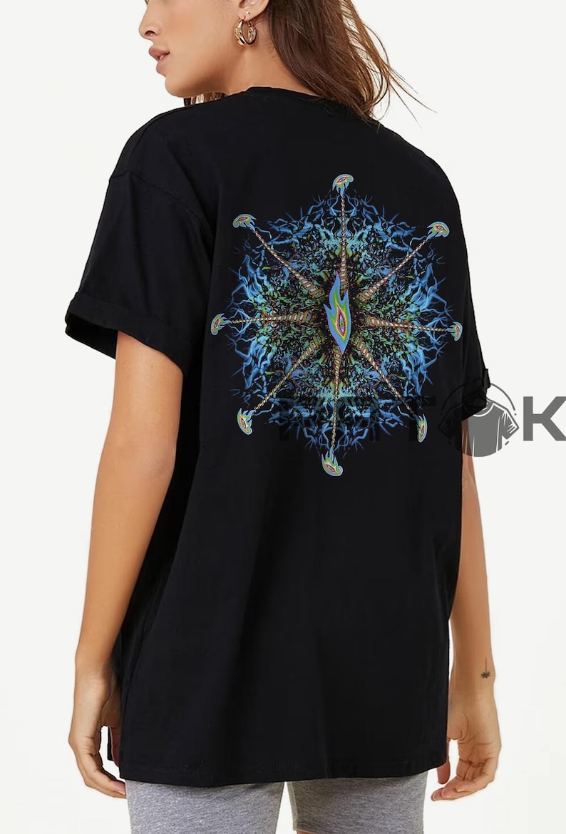 May include: Black t-shirt with a vibrant, detailed design on the back. The design is a symmetrical, abstract pattern with blue, green, and yellow tones. The shirt has short sleeves and a loose fit.