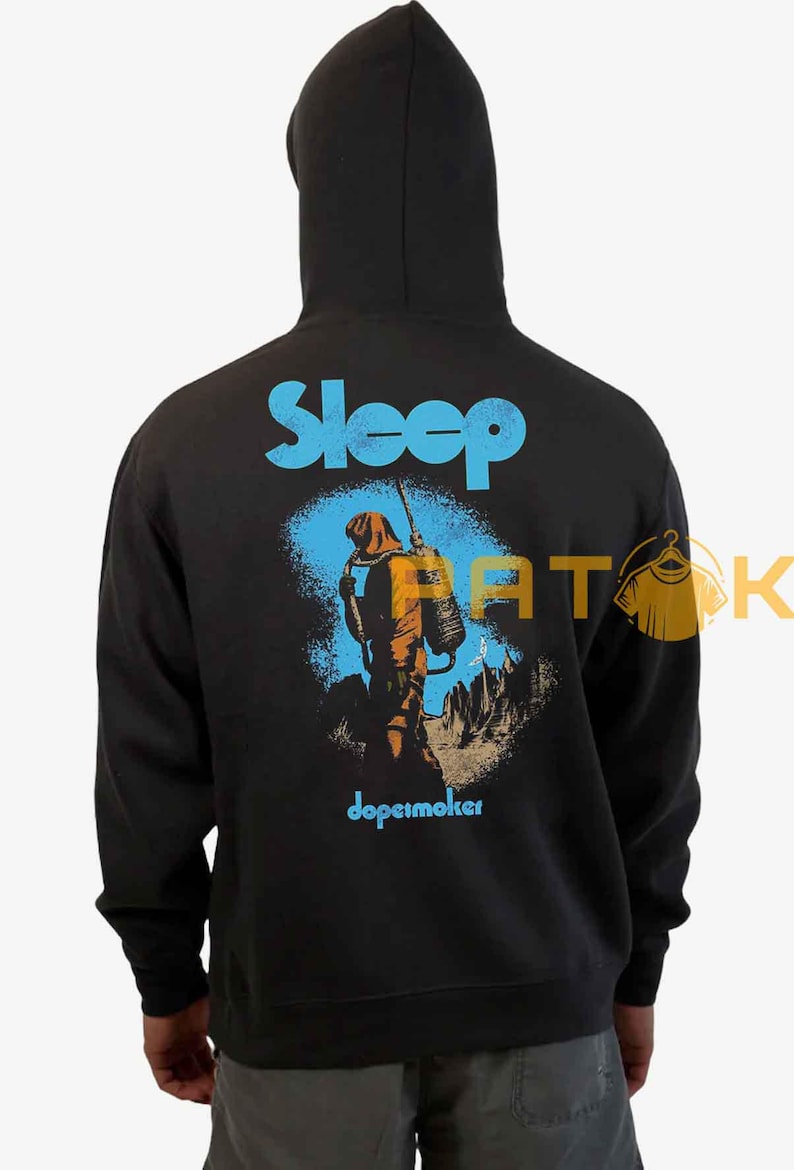 Pu&ograve; includere: Felpa con cappuccio nera con la scritta "Sleep" in blu a blocchi sopra una grafica di una persona in tuta arancione con uno zaino. La parola "dopesmoker" &egrave; sotto in blu.