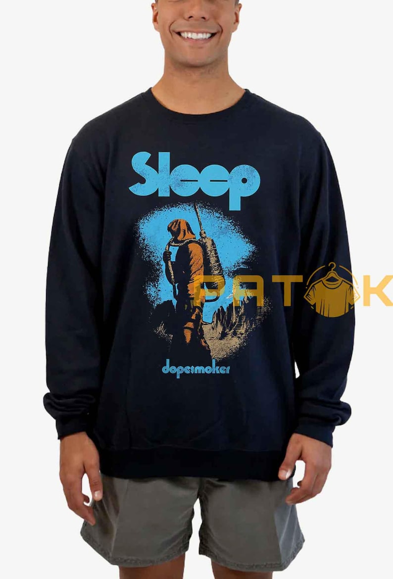 Pu&ograve; includere: Felpa blu navy con la scritta "Sleep" in azzurro. La grafica raffigura una figura con zaino e bastone, con la parola "dopesmoker" sotto.