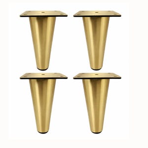 May include: A set of four conical furniture legs with a brushed gold finish. Each leg features a square mounting plate at the top with four pre-drilled holes for attachment and a black protective base at the bottom to prevent floor damage.