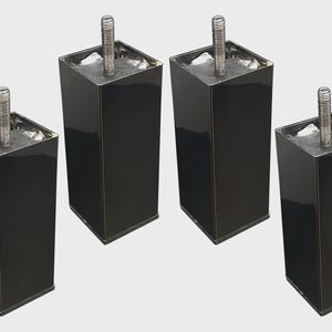 May include: Four black, square furniture legs with a glossy finish. Each leg has a threaded metal bolt extending from the top. The legs are evenly spaced and appear to be new.