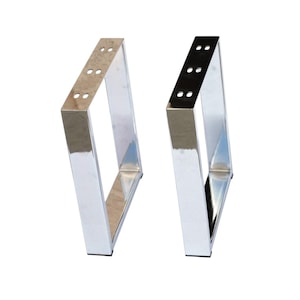 May include: Two rectangular furniture legs with a polished chrome finish. Each leg features a hollow center and a flat top mounting plate with six pre-drilled circular holes for attachment. The metal surfaces are reflective and smooth.