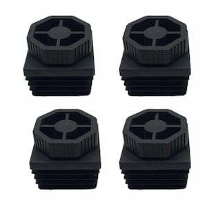 May include: Four black plastic furniture leg inserts. Each insert has a square base with ribbed sides and a round, octagonal top with a cross-shaped design. The inserts are designed to fit into the legs of furniture.