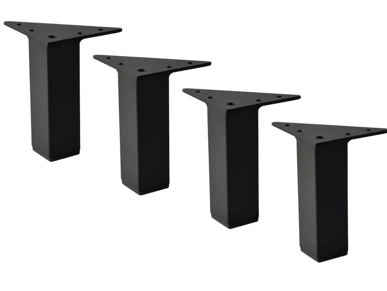 May include: Four black metal furniture legs. Each leg has a triangular top with pre-drilled holes for mounting and a rectangular base. The legs are designed for furniture such as tables, chairs, or sofas.