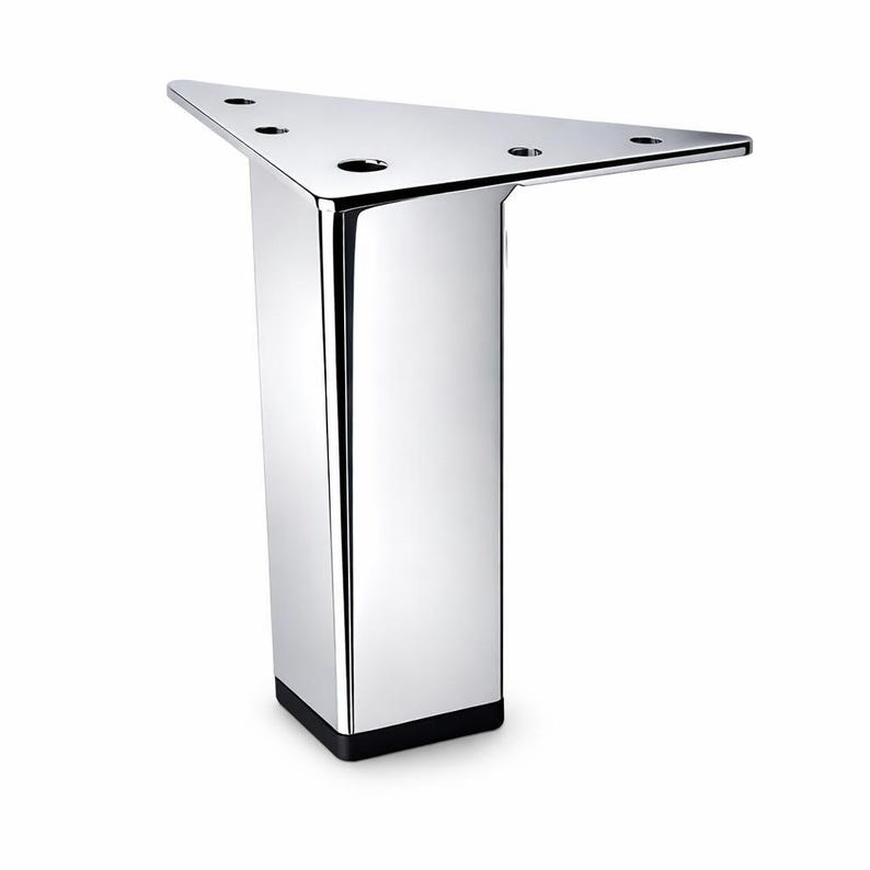 May include: A chrome-finished furniture leg with a triangular top and a rectangular base. The leg has a polished, reflective surface and three circular holes on the top. The base is black. This modern furniture component is designed for stability and style.