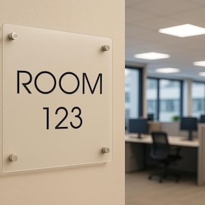 Könnte beinhalten: Ein rechteckiges, transparentes Schild mit dem Text "ROOM 123" in schwarzer Schrift. Das Schild ist mit vier silberfarbenen Befestigungen an einer beigefarbenen Wand befestigt. Der Hintergrund zeigt einen Büroraum.