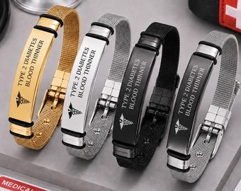Puede incluir: Cuatro pulseras de alerta médica con correas de malla en tonos oro, plata, negro y gris oscuro. Cada una presenta una placa rectangular grabada con el texto TYPE 2 DIABETES BLOOD THINNER y un símbolo de caduceo con detalles en negro.