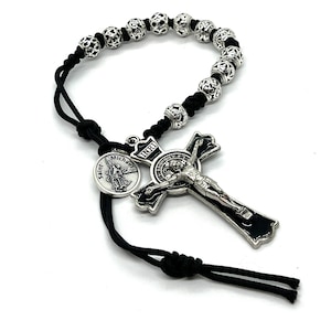 One decade rosary created with 95 black micro paracord with ornate, detailed silver Tibetan beads and black and silver stainless crucifix.