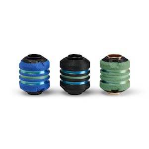 May include: Three decorative objects with a cylindrical shape. One is blue, another is black, and the third is green. Each has a black top and is accented with bands of a contrasting color. The objects are set against a white background.