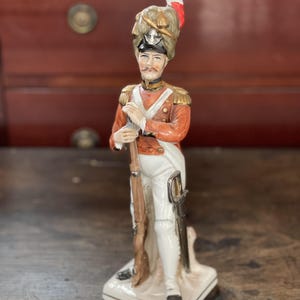 Vintage porseleinen soldatenbeeldje uit de jaren 40 – handgeschilderd militair decor met geweer en sabel
