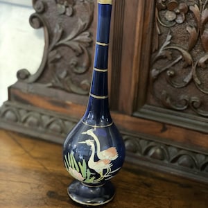 Hermoso frasco de perfume vintage azul con detalles decorativos dorados y diseños hechos a mano.