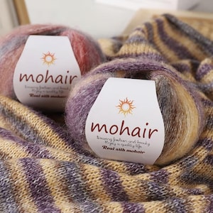 May include: A white ceramic mug with a black handle and the text "But First, Coffee" in a bold, black font. The mug is filled with a dark liquid, likely coffee, and rests on a light-coloured surface.