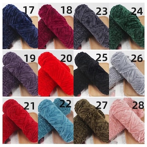 K&ouml;nnte beinhalten: Eine Sammlung farbenfroher Samtgarngarne, die jeweils mit einer Nummer versehen sind. Die Garnfarben umfassen Blaut&ouml;ne, Rot, Lila, Schwarz, Grau, Gr&uuml;n und Rosa. Die weiche, pl&uuml;schige Textur des Garns ist deutlich sichtbar.