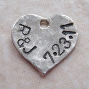 May include: Silver heart-shaped charm with the inscription "R & J 1.23.14" engraved on it.