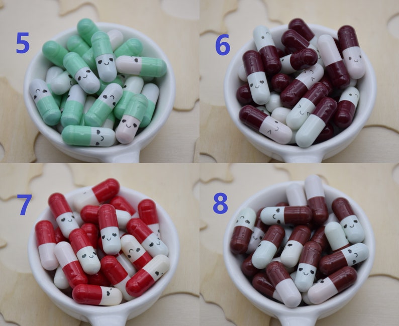 Puede incluir: Una colecci&oacute;n de cuentas coloridas en forma de c&aacute;psula sonriente en un cuenco de cer&aacute;mica blanco. Las cuentas est&aacute;n en varias combinaciones de colores, incluyendo verde y blanco, burdeos y blanco, y rojo y blanco. Cada cuenta tiene una cara sonriente.