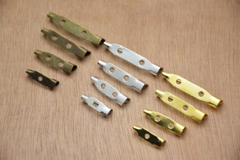 K&ouml;nnte beinhalten: Sortiment an Sicherheitsnadelr&uuml;cken aus Metall in Gold-, Silber- und Messingfarben. Die Nadeln sind in verschiedenen Gr&ouml;&szlig;en und ideal zum Basteln und Schmuckmachen.