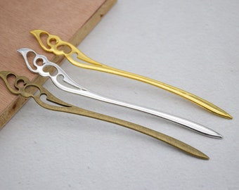 May include: Three decorative hair sticks with ornate designs. The sticks are made of metal and are available in gold, silver, and bronze.