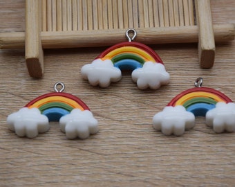 May include: Three rainbow charms with white cloud accents. Each charm has a silver loop for attaching to a necklace, bracelet, or other jewelry.
